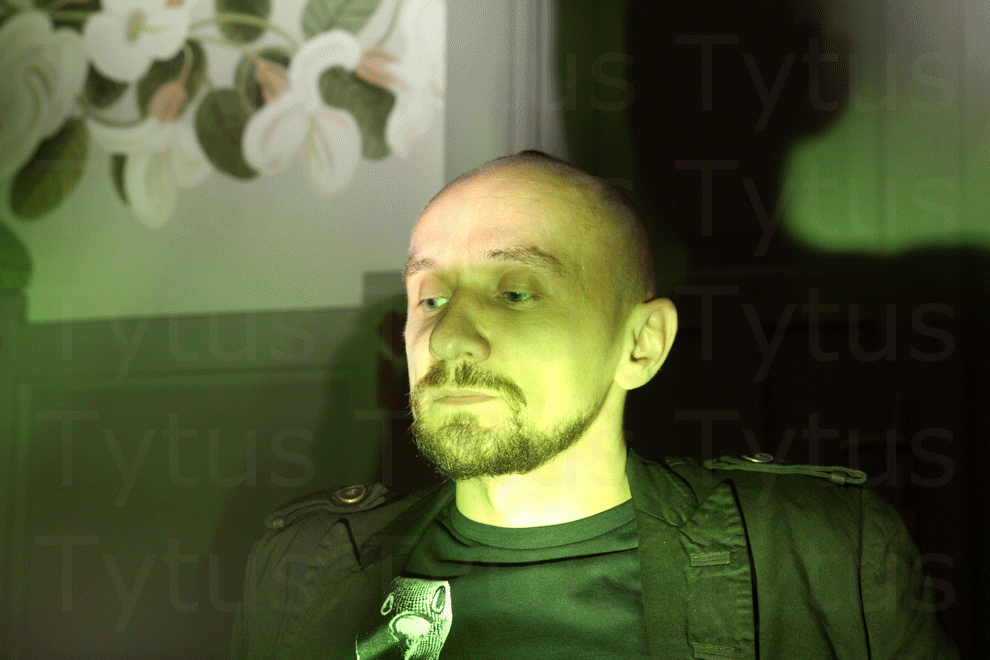 Jan Klata in the shadow of a green glass bottle with mineral water